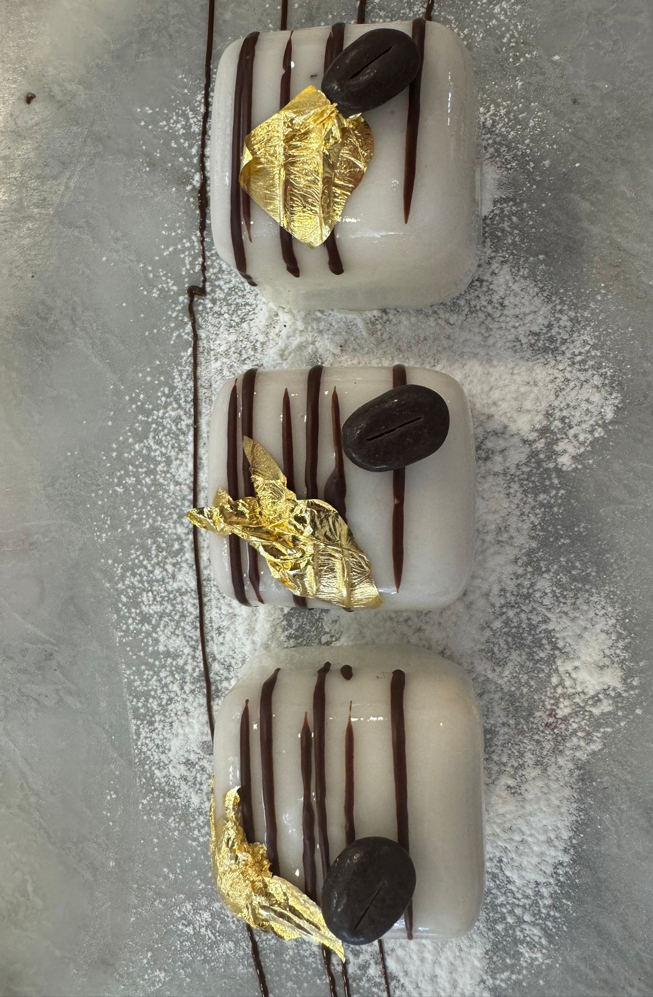 Coffee panna cotta with chocolate drizzle and gold leaf