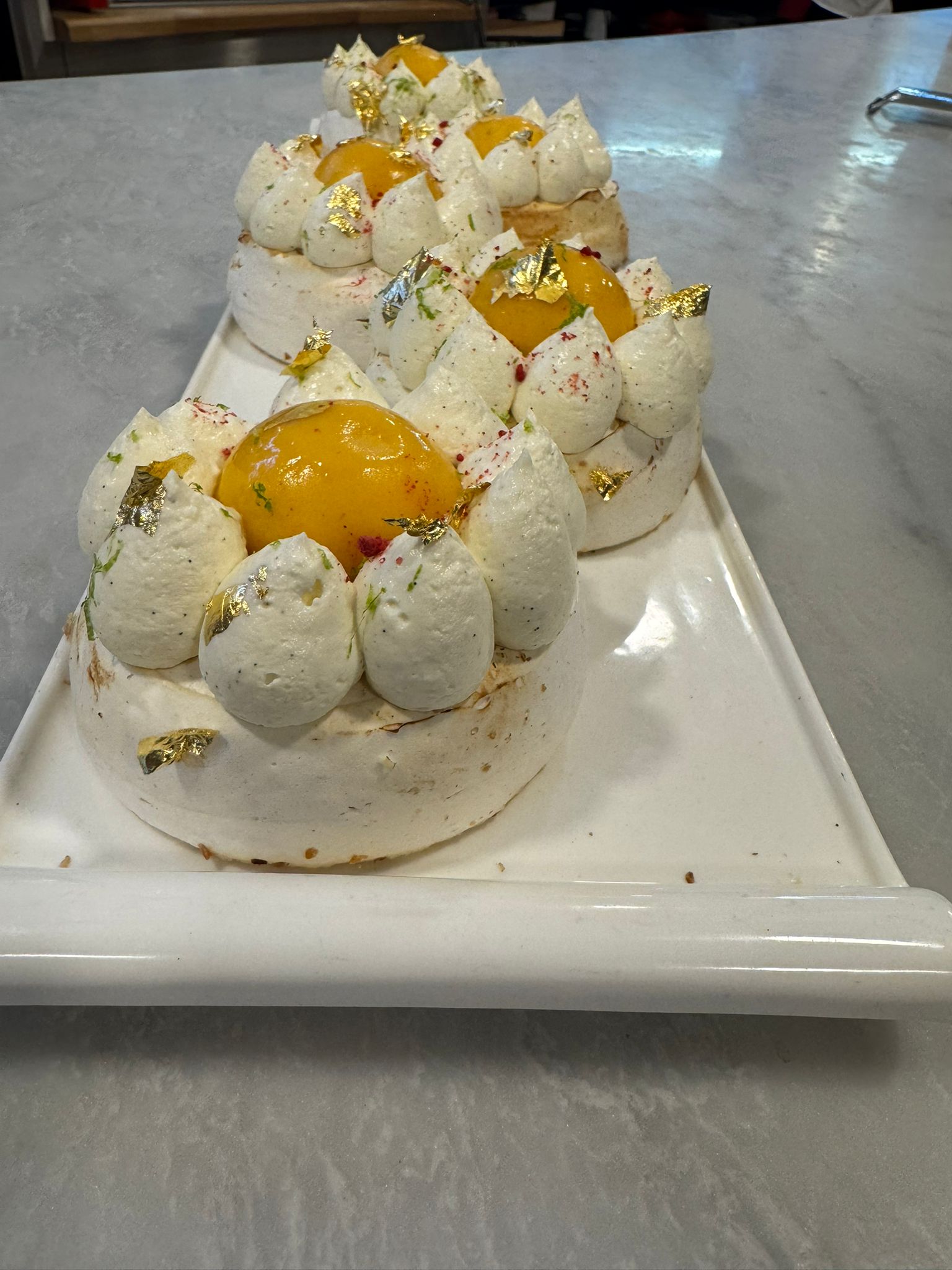 Mango and lime pavlova with gold leaf